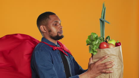 African-american-guy-posing-as-a-superhero-with-fresh-ripe-produce