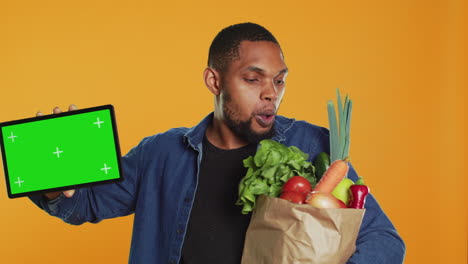 African-american-guy-showing-a-tablet-with-greenscreen-layout