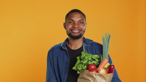 Porträt-Eines-Afroamerikaners,-Der-Mit-Einer-Papiertüte-Voller-Lebensmittel-Posiert
