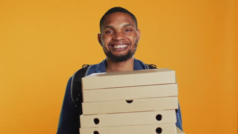 Repartidor-De-Pizzería-Afroamericano-Sosteniendo-Una-Pila-De-Cajas-De-Pizza