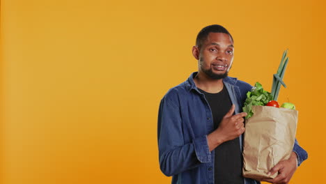 African-american-person-pointing-at-ethically-sourced-fruits-and-veggies
