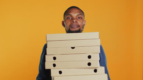 Afroamerikanischer-Pizzeria-Kurier-Trägt-Stapel-Pizza-Für-Express-Lieferung