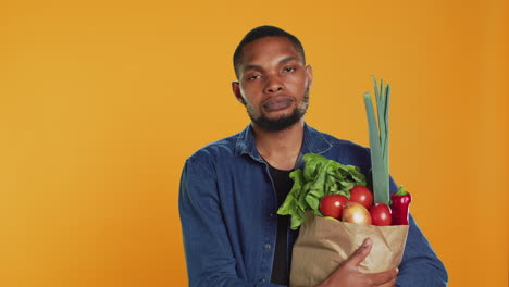 Porträt-Eines-Afroamerikaners,-Der-Eine-Papiertüte-Voller-Bio-Lebensmittel-Hält