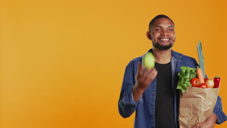 Cheerful-person-juggling-with-a-green-ripe-apple-on-camera
