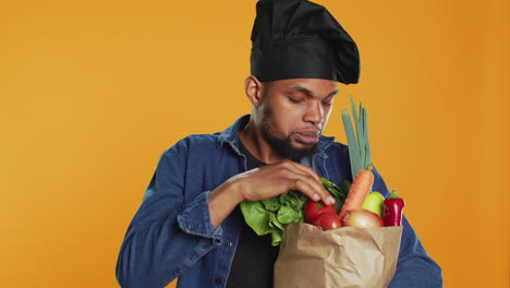 African-american-cook-examining-his-groceries-in-a-paper-bag