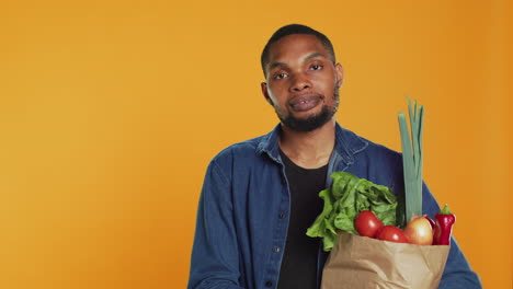 Portrait-of-smiling-model-carrying-bag-full-of-fresh-bio-groceries