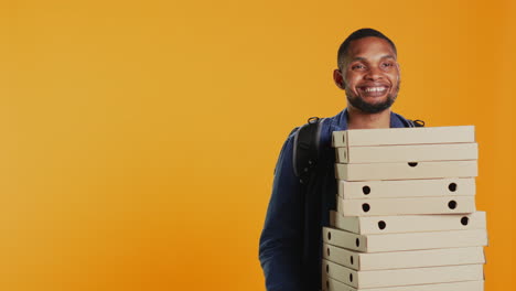 Afroamerikanischer-Pizzeria-Lieferant-Hält-Stapel-Pizzakartons
