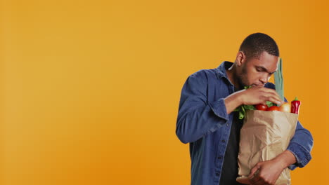 Young-adult-examining-all-his-fresh-bio-groceries-to-be-ripe
