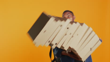 Clumsy-deliveryman-dropping-a-huge-stack-of-pizza-boxes-in-studio