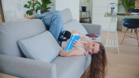 Woman-Lays-Upside-Down-on-Sofa-Reading-Book