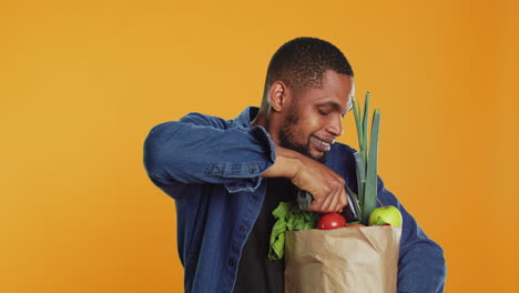 African-american-young-man-scanning-all-eco-friendly-produce-in-studio