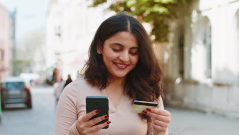 Mujer-India-Que-Usa-Un-Teléfono-Inteligente-Con-Tarjeta-Bancaria-De-Crédito-Mientras-Transfiere-Dinero-Para-Compras-En-Línea