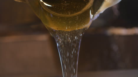 Pouring-Strained-Golden-Honey-into-Jar