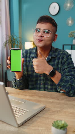 Indian-business-man-holds-smartphone-with-green-screen-chroma-key-mock-up-recommend-good-application