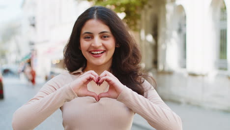Indian-woman-makes-symbol-of-love,-showing-heart-sign-to-camera,-express-romantic-positive-feelings