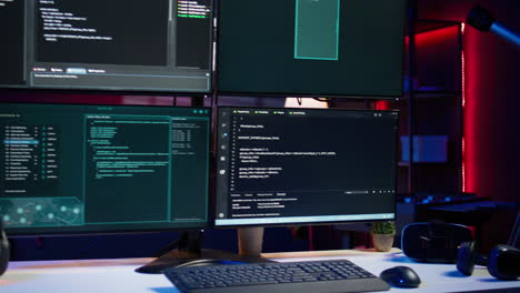 Close-up-of-code-running-on-computer-displays-in-empty-apartment-used-by-hacker