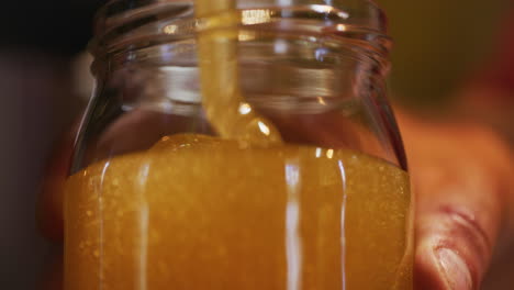 Nahaufnahme-Vom-Eingießen-Von-Frischem-Bio-Honig-In-Ein-Glas
