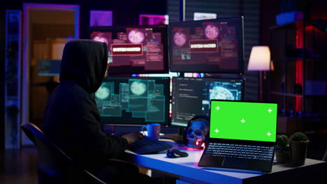 Hacker-doing-computer-sabotage-using-trojan-ransomware-on-green-screen-laptop
