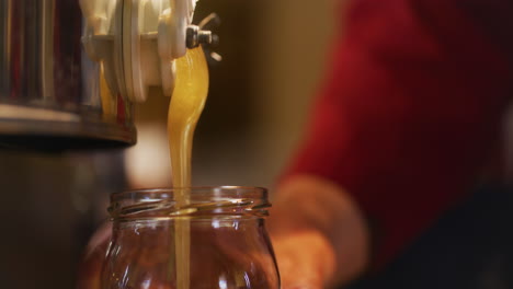 Beekeeper-Pours-Fresh-Organic-Honey-into-Jar