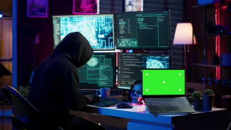 Hacker-Que-Utiliza-Una-Computadora-Portátil-Con-Pantalla-Verde-Para-Implementar-Malware-En-Dispositivos-No-Seguros