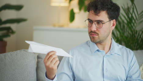 Thoughtful-Businessman-with-Paper-Airplane-Model