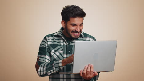 Indian-man-working-on-laptop-project,-enjoying-results,-winning-lottery,-celebrating-success,-winner