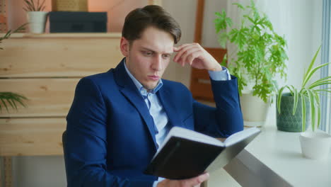 Pensive-Businessman-Reads-Notebook