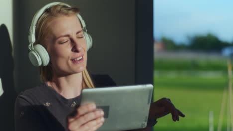 Portrait-of-Satisfied-Woman-While-Listening-to-Music-on-Digital-Tablet