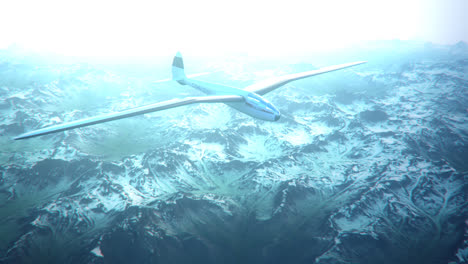 An-aerial-view-of-the-white-sailplane-with-no-propeller-calmly-gliding-in-the-sky,-over-snow-covered-mountains.-Flying-aerodynamic-aircraft-is-a-great-way-of-spend-leisure-time.