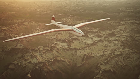 An-aerial-view-of-the-white-sailplane-with-no-propeller-calmly-gliding-in-the-sky,-over-snow-covered-mountains.-Flying-aerodynamic-aircraft-is-a-great-way-of-spend-leisure-time.