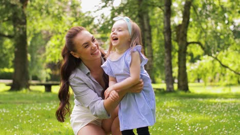 Happy-Mother-with-Little-Daughter-Playing-at-Park.family,-motherhood-and-people-concept-happy-mother-with-little-daughter-playing-at-summer-park-or-garden