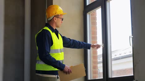 Male-Builder-with-Clipboard-Checking-Window.construction-business-and-building-concept-male-builder-with-clipboard-checking-window