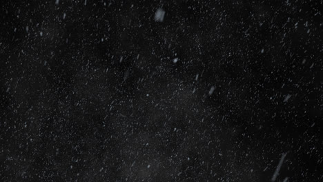 Winter-snowfall.-Low-angle-shot-of-a-dense-snow-against-a-black-background.-White-snow-particles-falling-from-the-dark-sky-during-blizzard.-Perfect-for-any-meteorology-related-purposes.