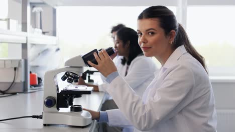 Scientists-with-Microscopes-Working-in-Laboratory.science-research,-work-and-people-concept-international-female-scientists-with-microscopes-working-in-laboratory