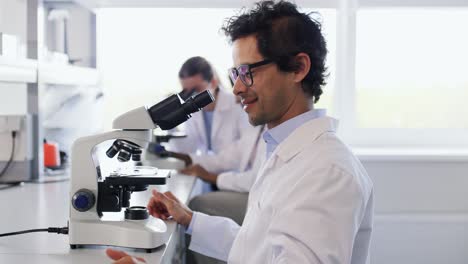 Scientists-with-Microscopes-Working-in-Laboratory.science-research,-work-and-people-concept-international-female-scientists-with-microscopes-working-in-laboratory