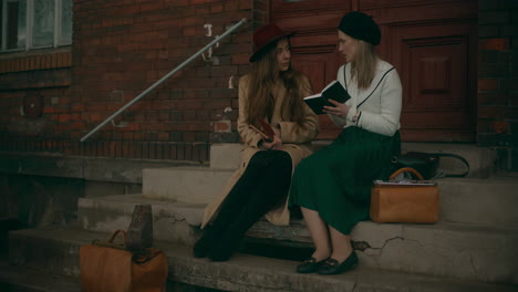 Two-Women-Reading-Book-At-Stairs