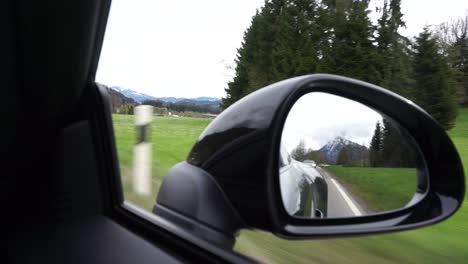 Ein-Auto-Im-Seitenspiegel,-Das-In-Der-Nähe-Von-Feldern-Fährt