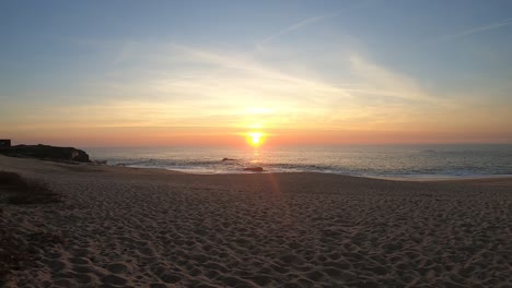 Ruhige-Meereswellen-Erklingen-Unter-Warmem-Sonnenuntergang-Am-Portugiesischen-Strand