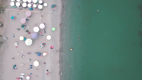 Aerial-drone-view-of-calm-Greek-coast-with-turquoise-waters-and-swimmers