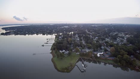A-drone-flight-taken-in-the-early-morning-from-Portsmouth-VA,-heading-towards-Norfolk-Virginia-showing-suburban-waterfront