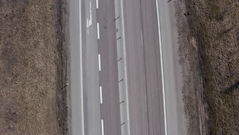 Top-down-shot-of-highway-in-Sweden-with-car-and-trucks-with-trailers-driving-by