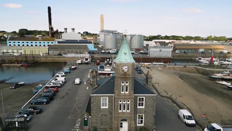Circular-drone-flight-centred-on-Clock-Tower-St-Sampsons-Harbour-Guernsey-showing-marina,boatyard,-power-station,-docks,-quayside-and-surrounding-urbanisation