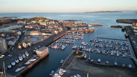 Flight-over-outer-harbour-St-Sampson-Guernsey-showing-marina,-boatyard,-ship,docks-cranes,-Vale-Castle-and-views-out-to-sea-with-Herm-in-the-distance-on-calm-sunny-day