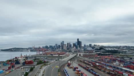 Große-Drohnenaufnahme-Der-Schiffscontainer-Von-Seattle-Mit-Den-Wolkenkratzern-Der-Innenstadt-In-Der-Ferne
