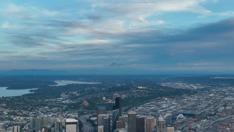 Drone-shot-of-Seattle's-skyscrapers-and-how-they-ascend-towards-Mount-Rainier-in-the-distance