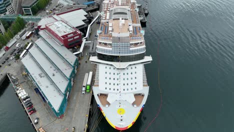 Overhead-aerial-view-of-a-large-cruise-ship-docked-in-Seattle-while-passengers-prepare-for-departure