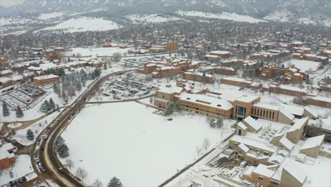 Aerial-flyover-snowy-cityscape-of-Boulder-with-University-during-winter