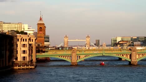 Static-wide-shot-of-boat-crossing-underneath-London-Brigde-on-Thames-River
