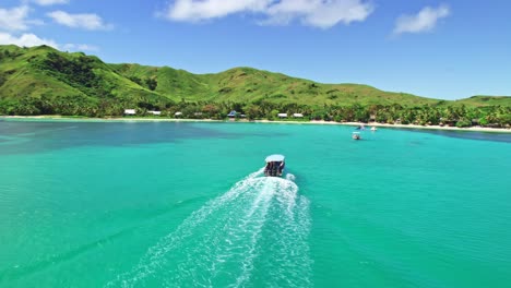 Boat-arriving-over-coral-reef-to-tropical-Island,-Nacula,-Yasawa,-Fiji