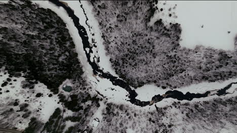 Aerial-scenic-cinematic-drone-straight-down-view-pan-Canadian-wilderness-mid-winter-near-north-Quebec-Stoneham-Ski-Resort-of-frozen-over-Sautaurski-River